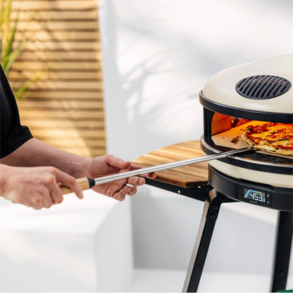 Person using a Gozney Balance Turning Peel to turn a pizza inside of a portable pizza oven.