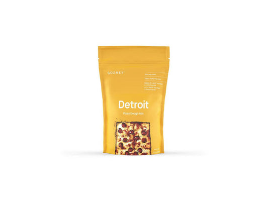 A yellow package of Gozney Detroit Pizza Dough Mix with a transparent window showing the product inside.