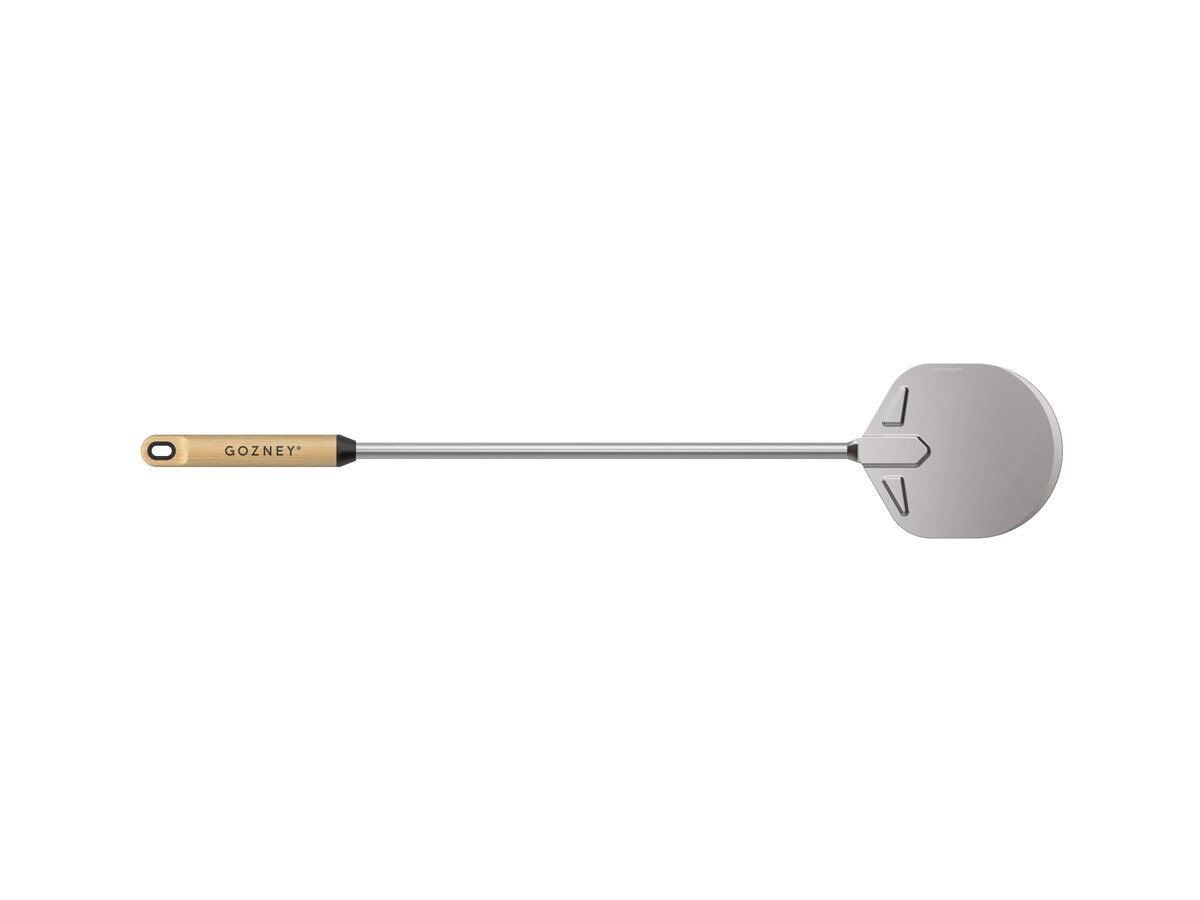 A Gozney Utility Turning Peel with a perforated aluminum blade and a wooden handle.