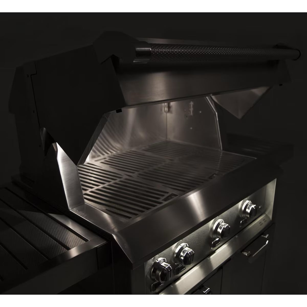 Hestan 30" Built In Gas Grill at nighttime with lights on and lid open