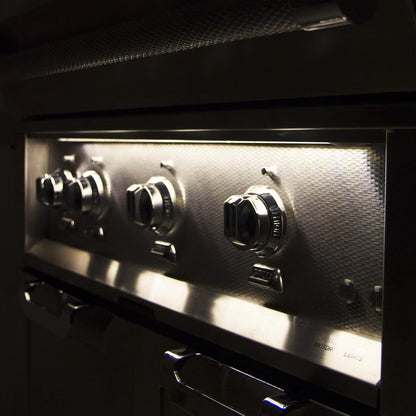Hestan 30" Built In Gas Grill at night time with knob lights on