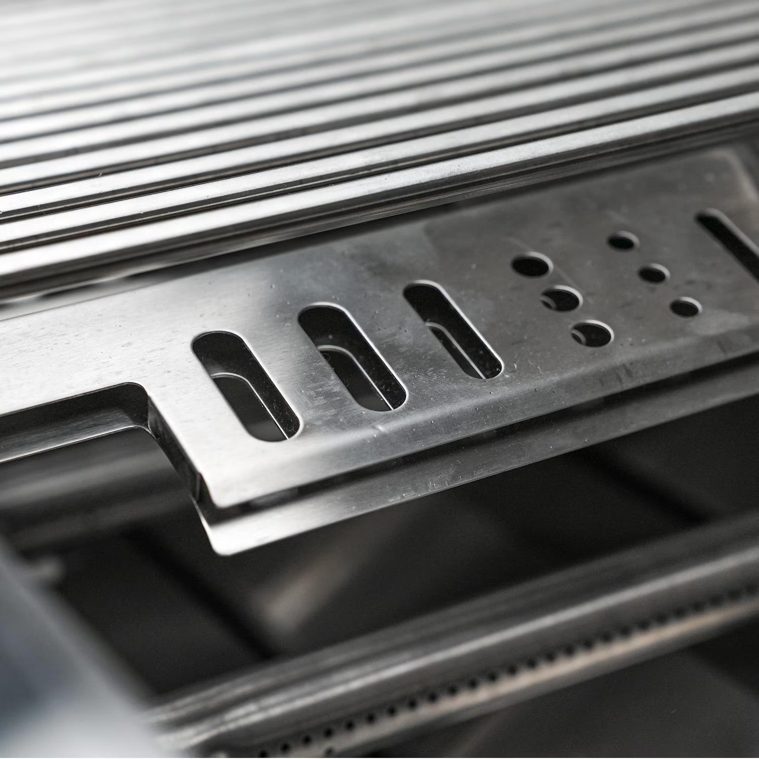 Close-up of a Mont Alpi metallic grill grate on a dark background