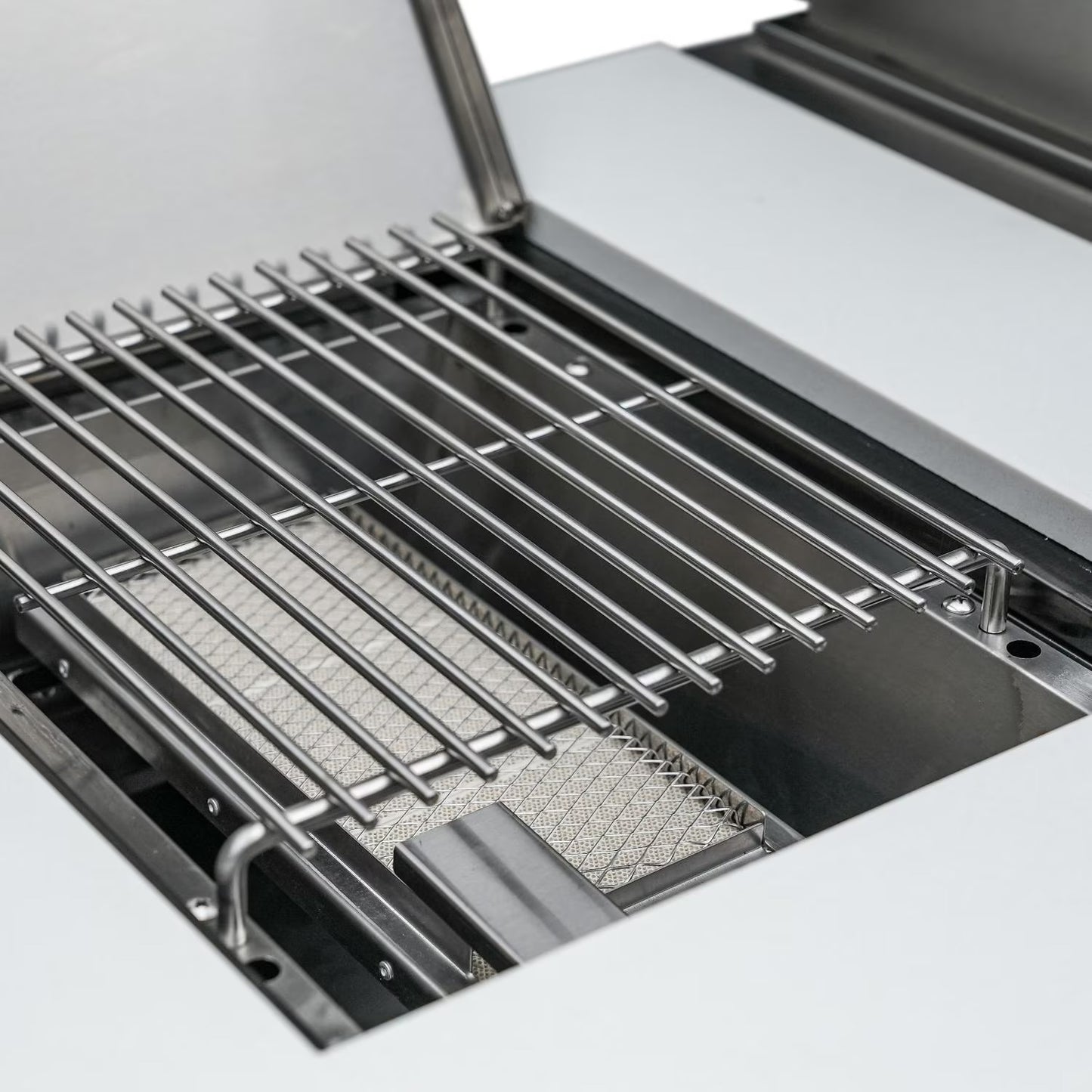 Mont Alpi Close-up of a grill with a metal grate and mesh pan on a white background