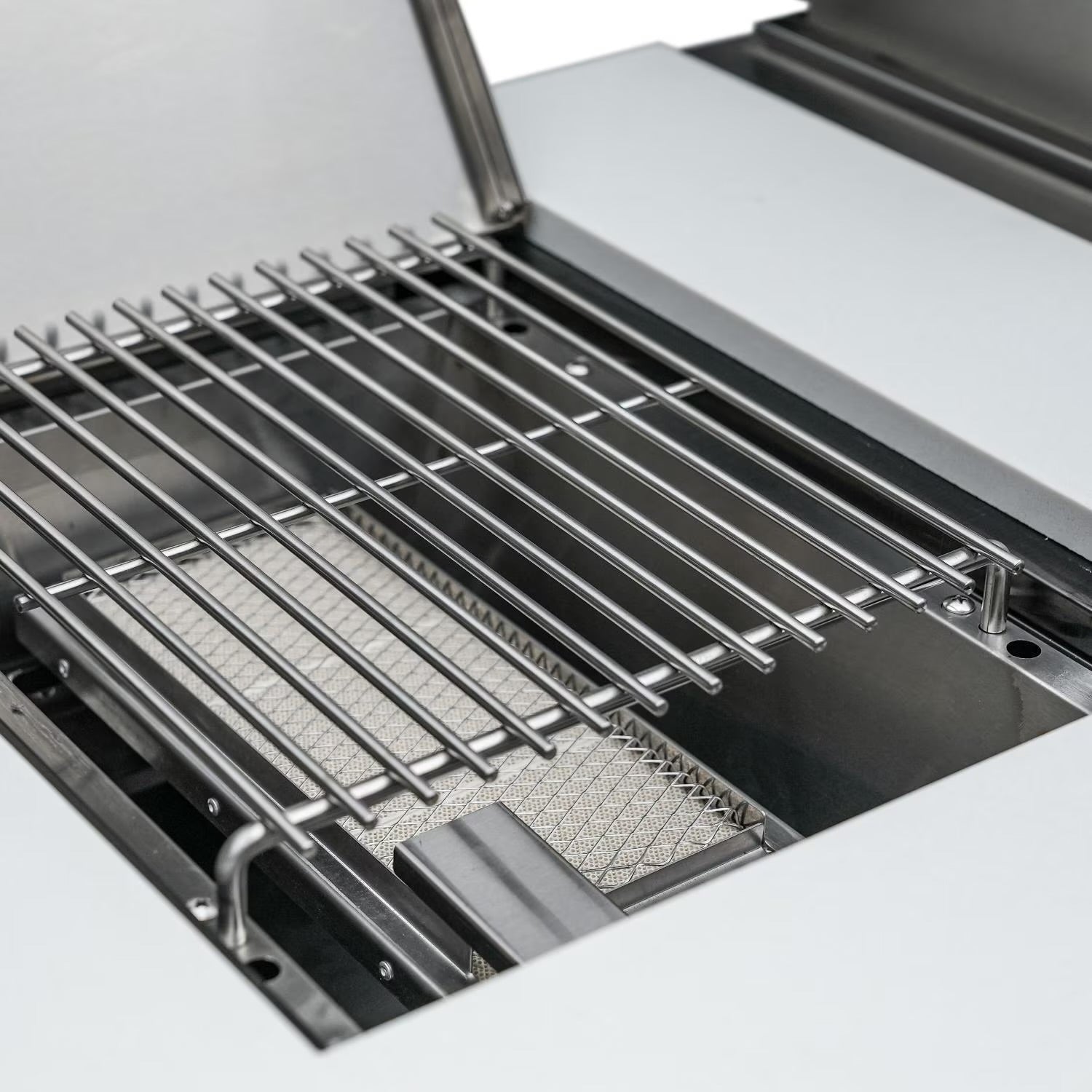 Mont Alpi Close-up of a grill with a metal grate and mesh pan on a white background