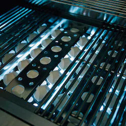 Close-up of a grill with metal grates and circular holes