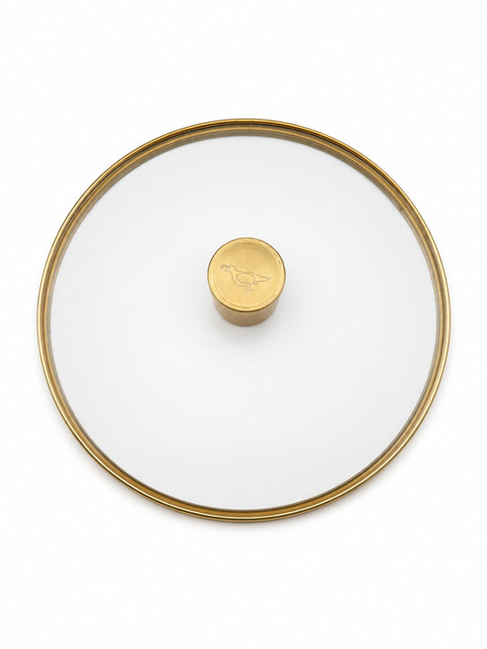 Smithey Ironware Glass lid with gold rim and central knob on a white background