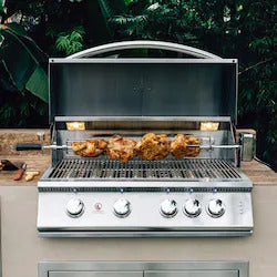 Stainless steel grill with chicken on a wooden deck