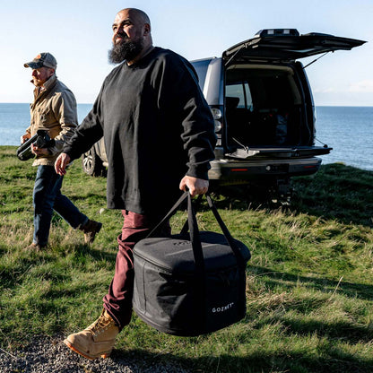 Two men with outdoor gear walking with Black Tread Venture bag with 'GOZNEY' branding on a mountain