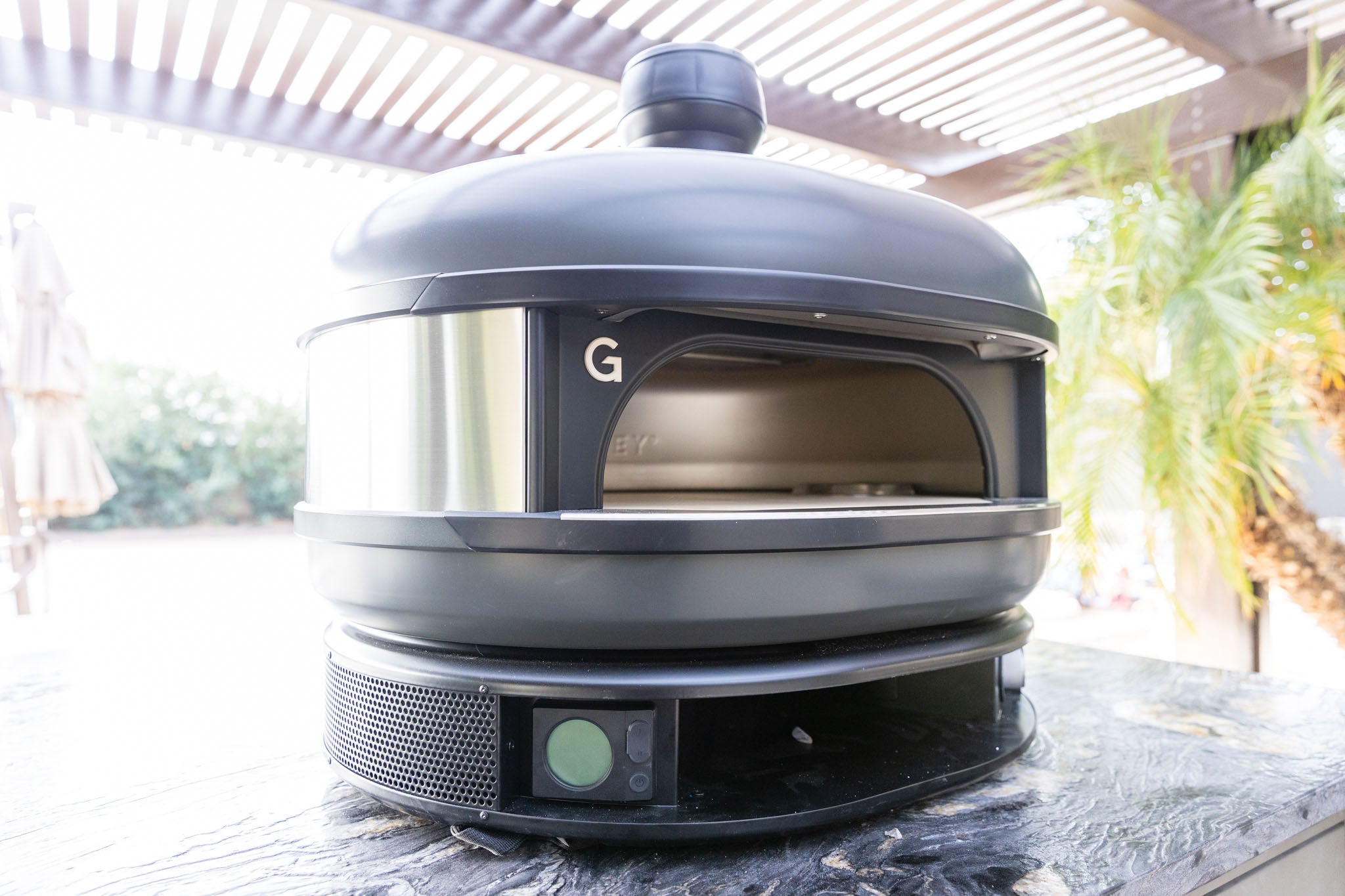 Gozney outdoor pizza oven on granite countertop in a Phoenix backyard kitchen